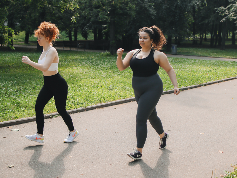Active woman walking in a Melbourne park as part of a belly fat loss routine