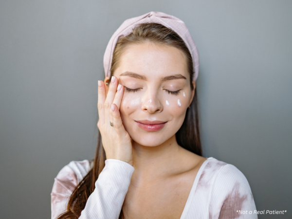 Woman applying moisturiser after laser skin treatment at Melbourne aesthetic clinic